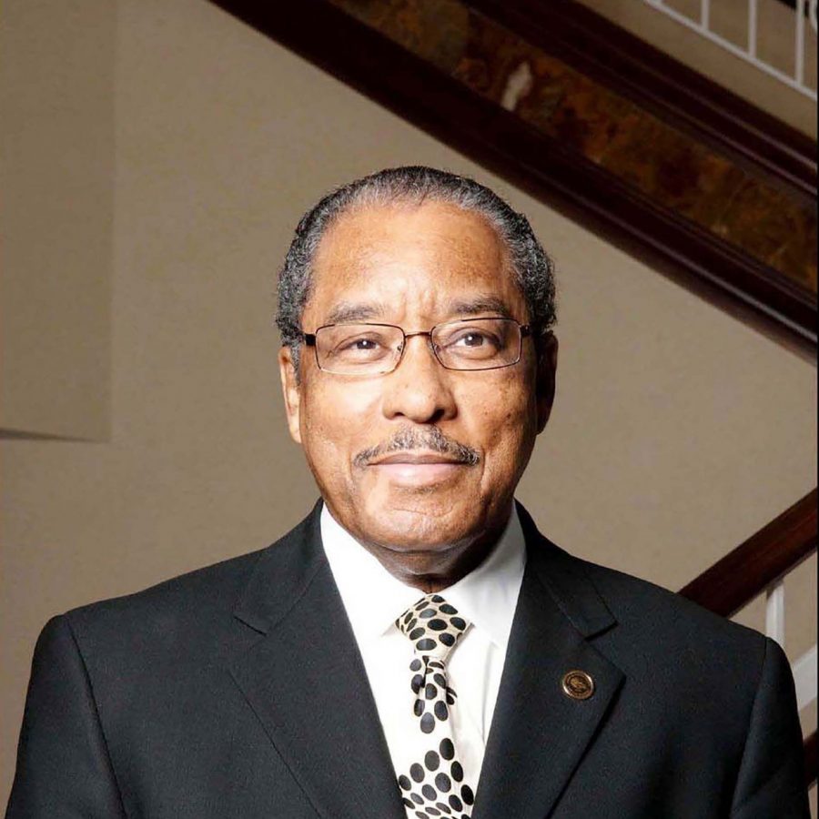 Julius Scruggs wearing a black suit and black and white tie