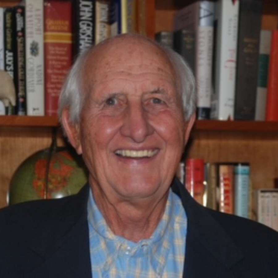 George Williamson in front of a bookshelf